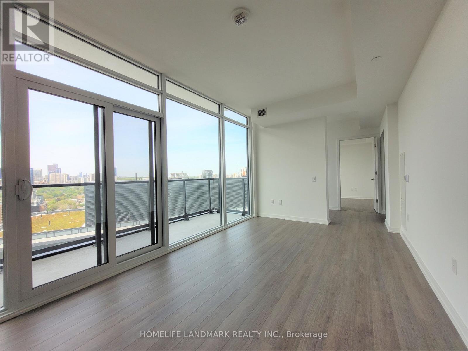 A room with a view of the city through large windows.