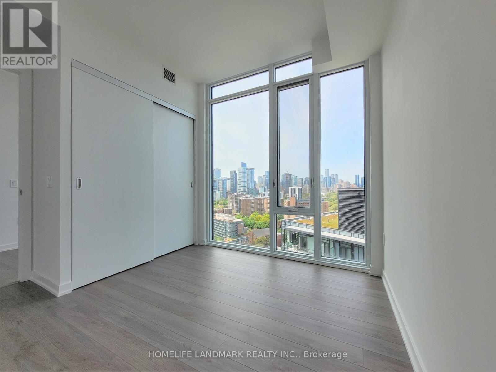 A room with a view of the city through large windows.