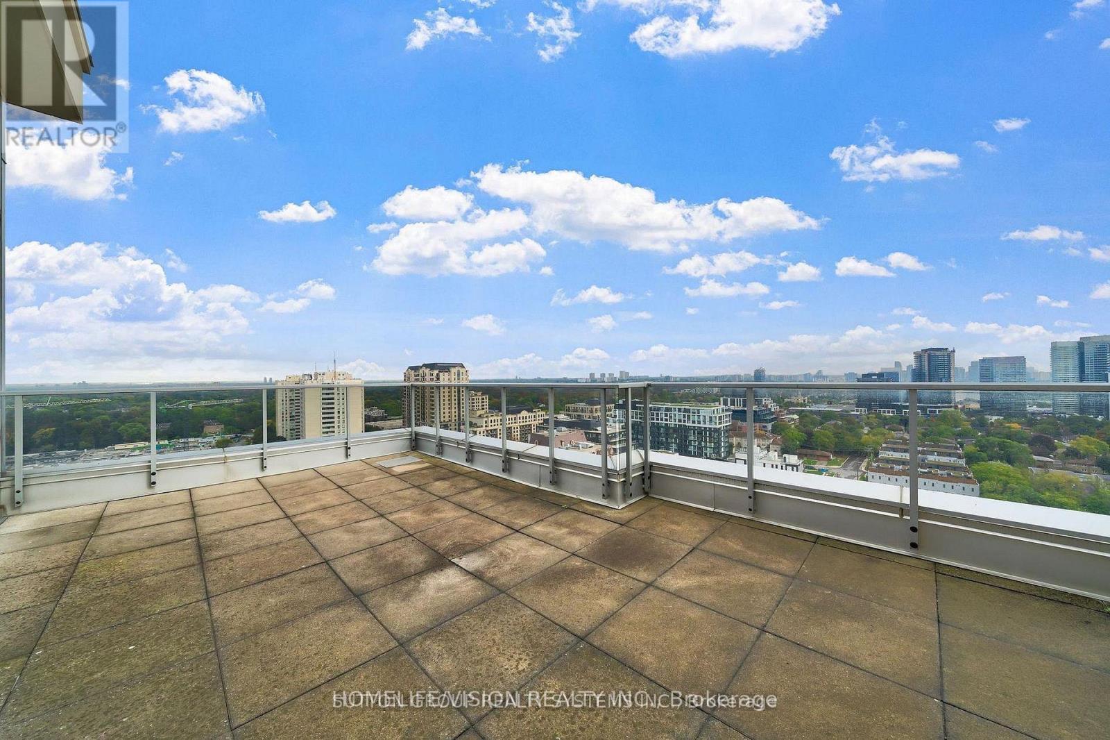 A rooftop with a large brown tiled surface and a metal railing.