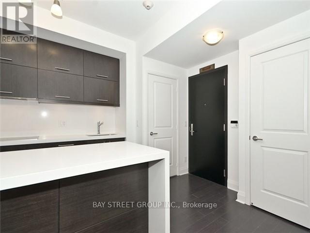 A kitchen with white countertops and dark brown cabinets.