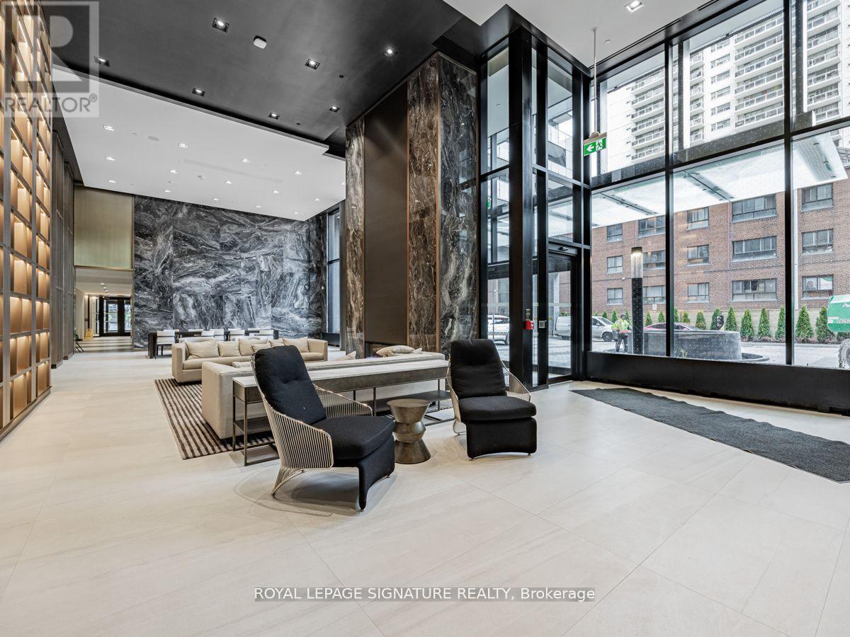 A modern interior space with a marble wall and black chairs.