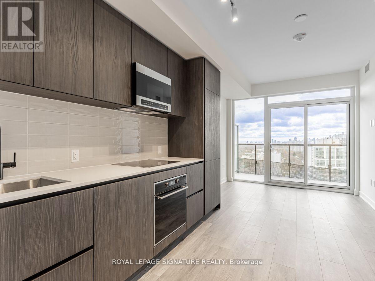 A modern kitchen with dark wood cabinets and stainless steel appliances.