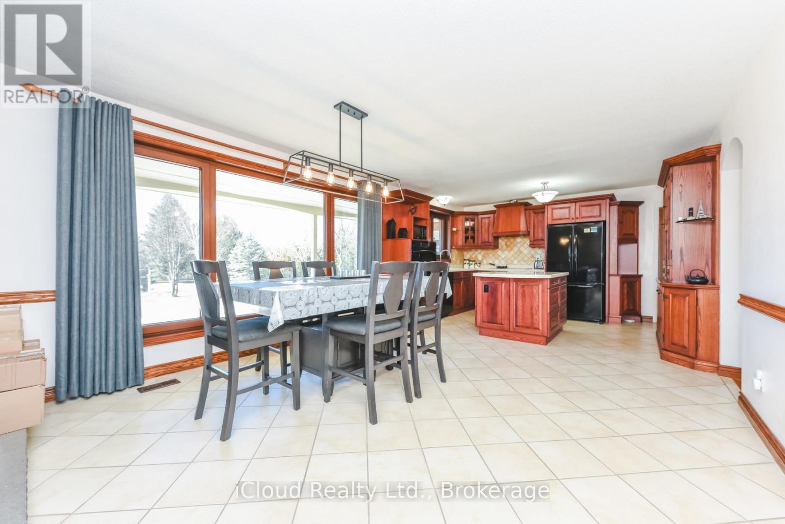 A dining room with a table set for six with a view of the snowy outdoors.