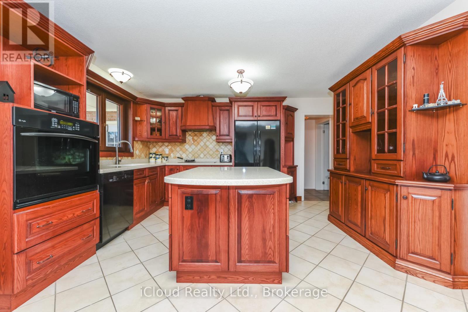 A kitchen with wooden cabinets and a white island.