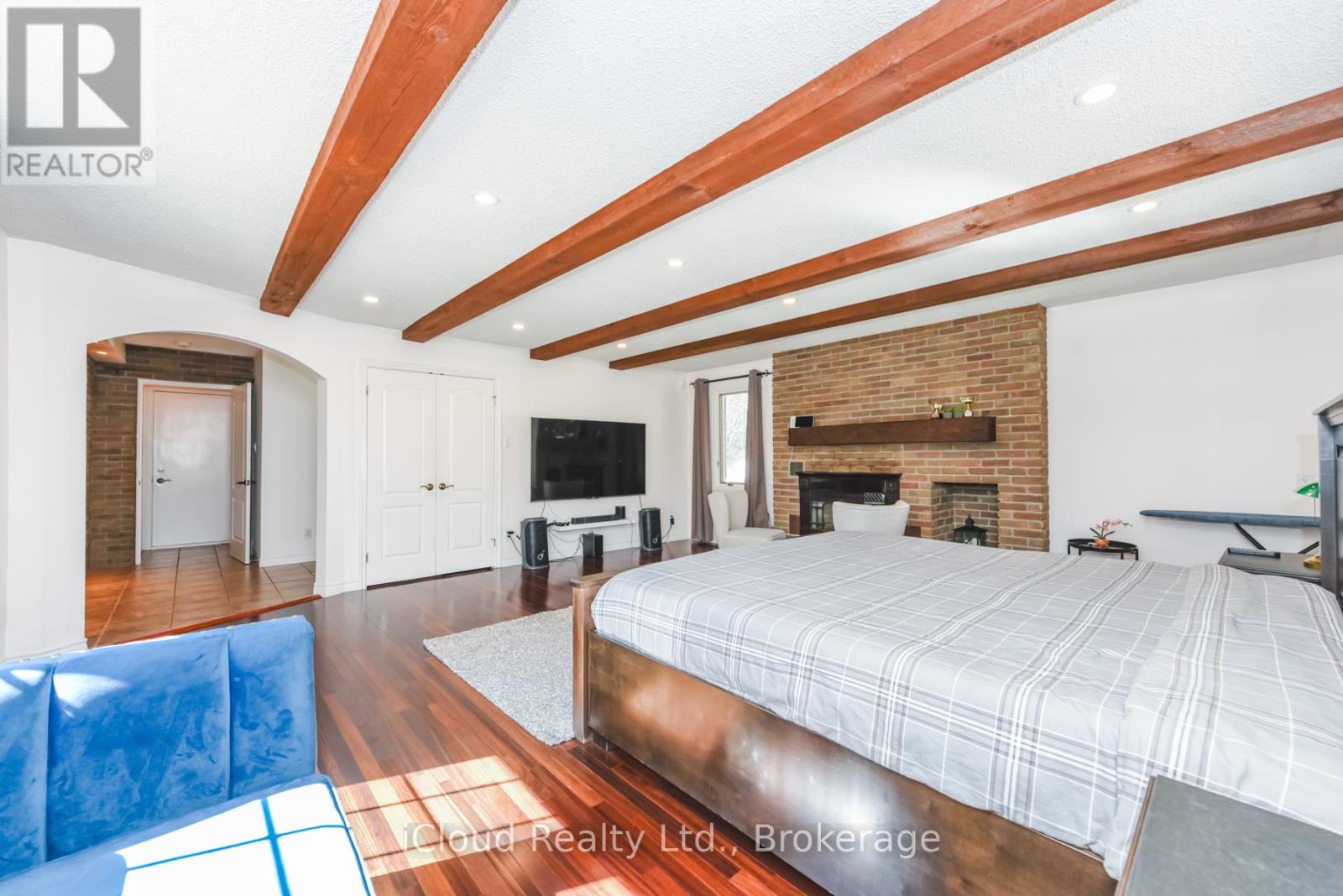 A bedroom with a large bed and a fireplace.
