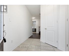 A hallway with white walls and a white door.