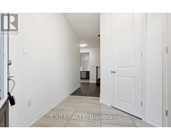 A hallway with white walls and a white door.