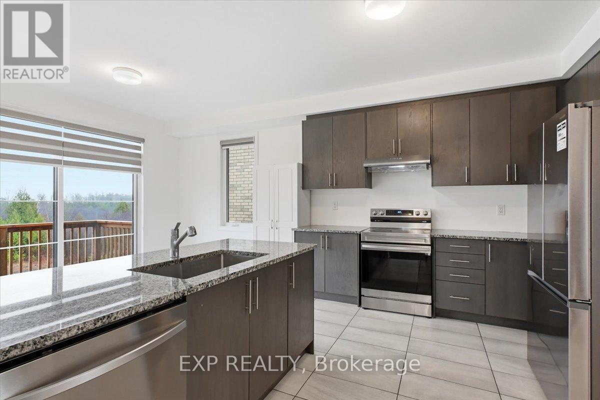 A modern kitchen with dark brown cabinets and stainless steel appliances.