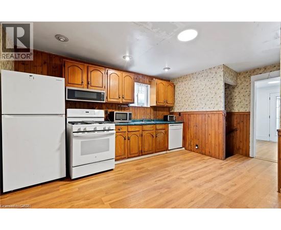 A kitchen with wooden cabinets and white appliances.