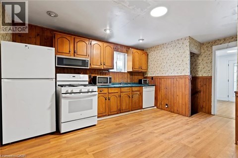 A kitchen with wooden cabinets and white appliances.