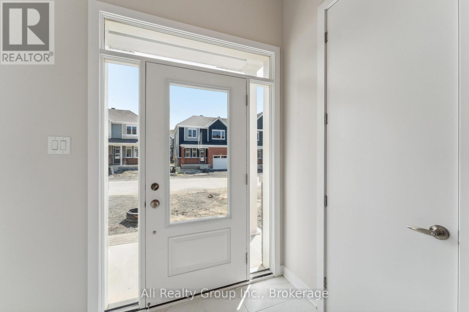 A white door with Ali Realty Group Inc. Brokerage logo on it.