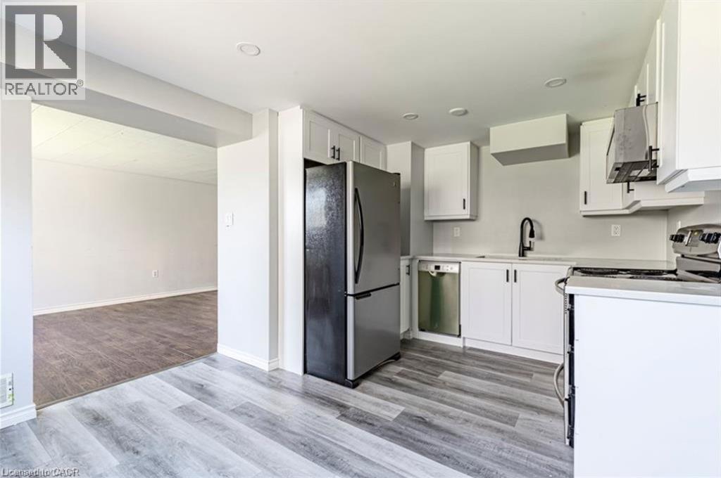 A kitchen with a black fridge and white cabinets.