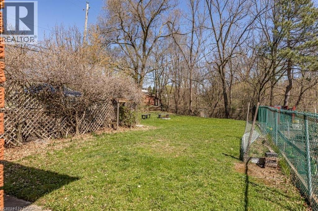 A backyard with a fence and a tree.