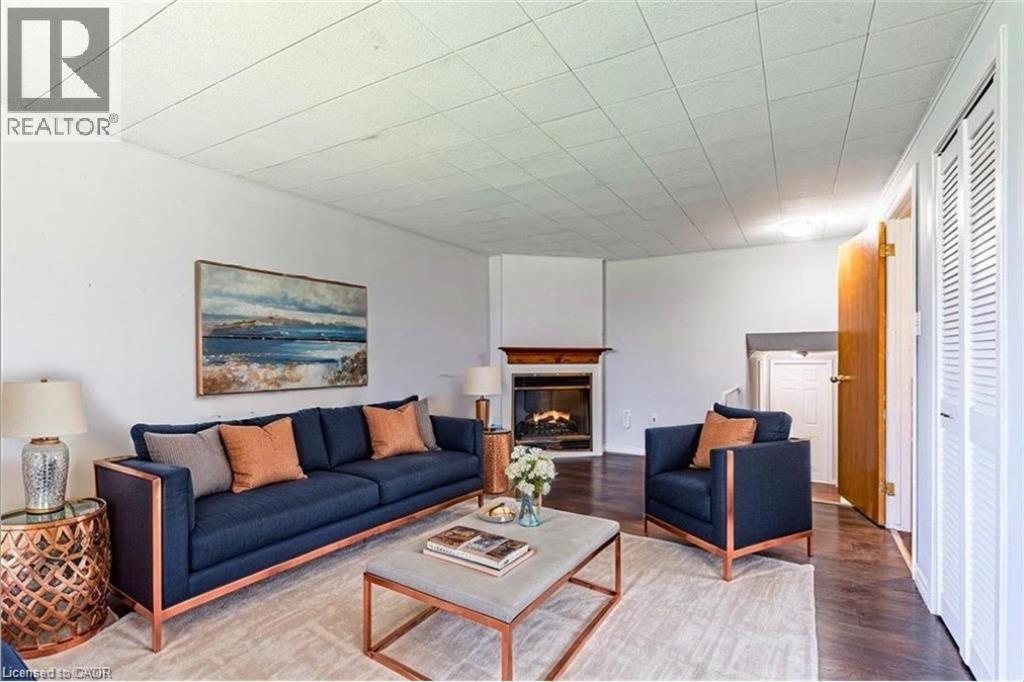 A living room with a blue couch and a painting on the wall.