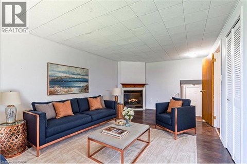 A living room with a blue couch and a painting on the wall.