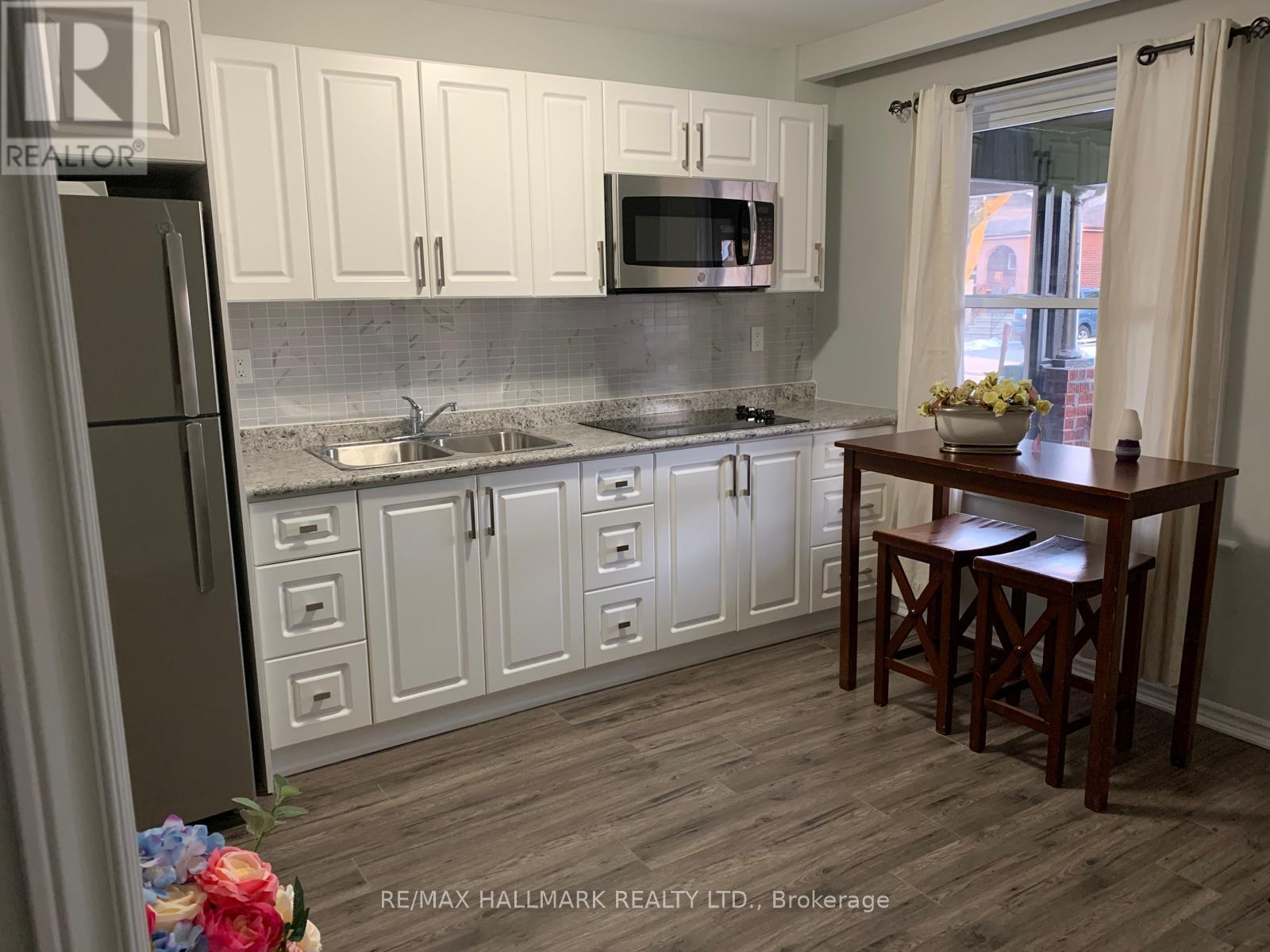 A kitchen with white cabinets and a wooden table.