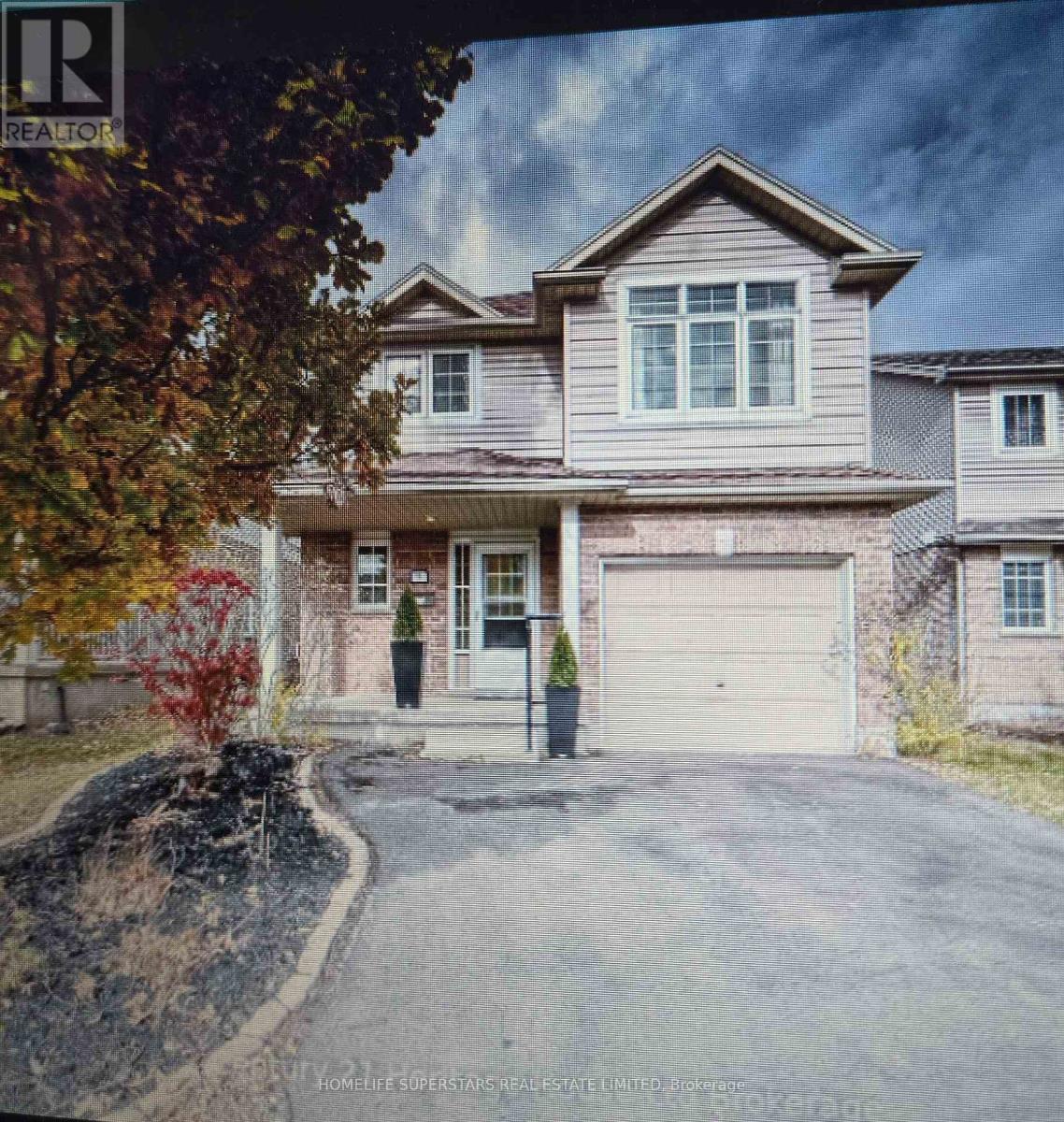 A real estate listing photo of a two-story house with a garage.