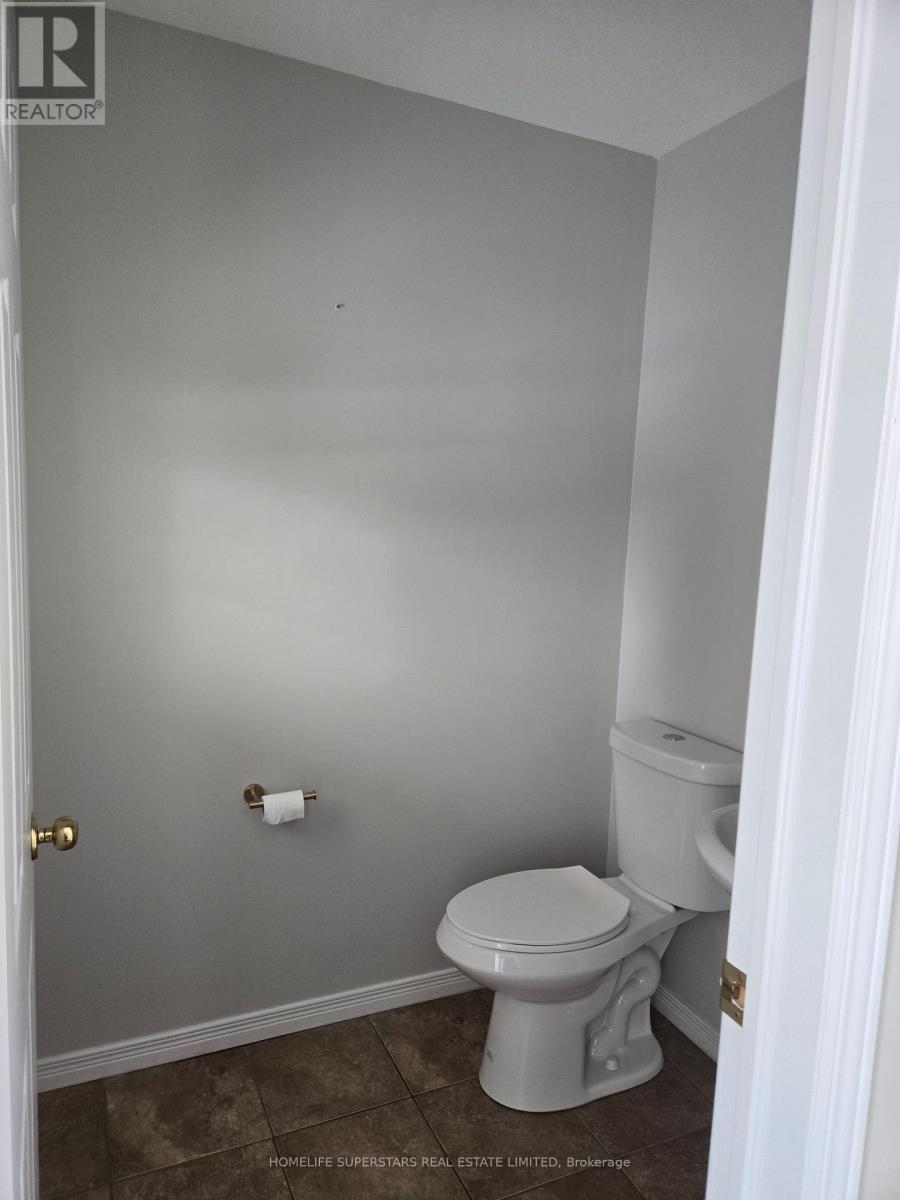 A white toilet in a small bathroom with a white door.