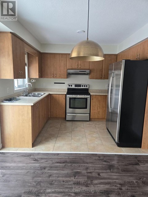 A kitchen with a black fridge and a stove top oven.