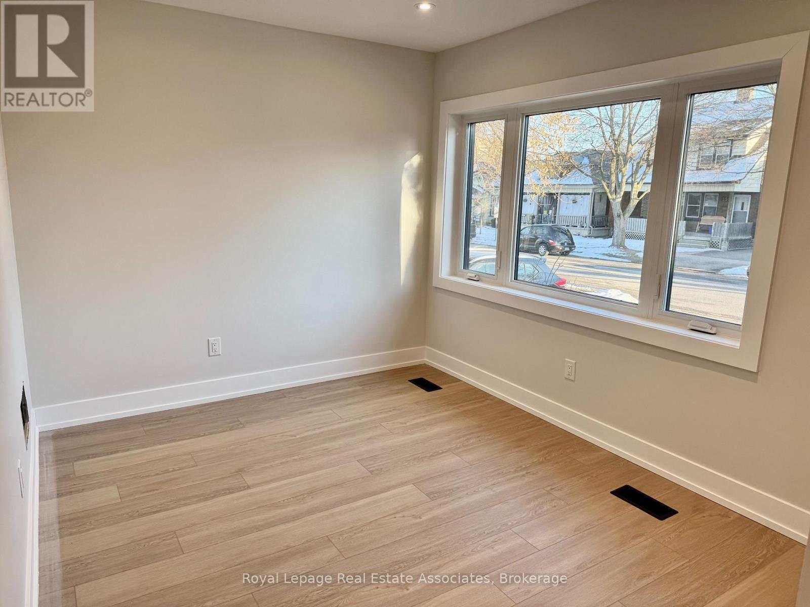 A room with a large window and wooden flooring.