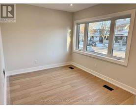 A room with a large window and wooden flooring.