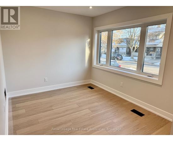 A room with a large window and wooden flooring.
