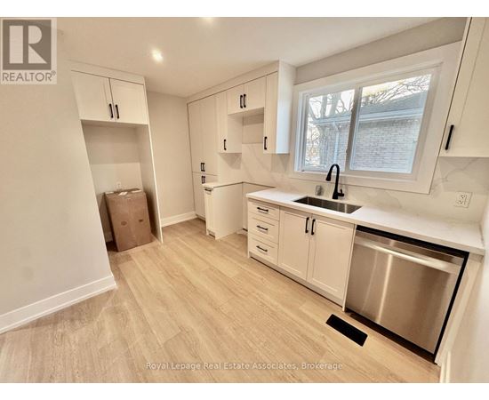 A kitchen with white cabinets and a stainless steel dishwasher.