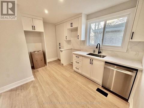 A kitchen with white cabinets and a stainless steel dishwasher.