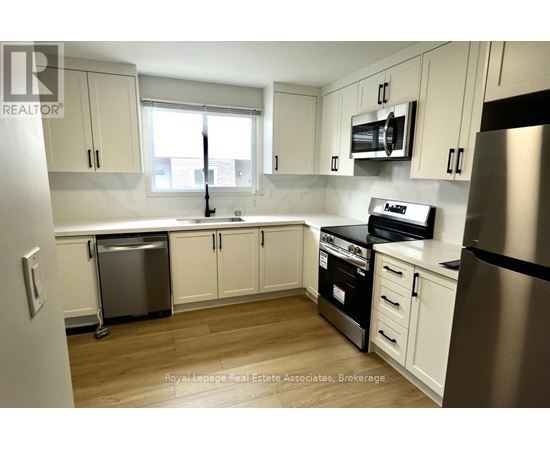 A kitchen with white cabinets and a stainless steel refrigerator.