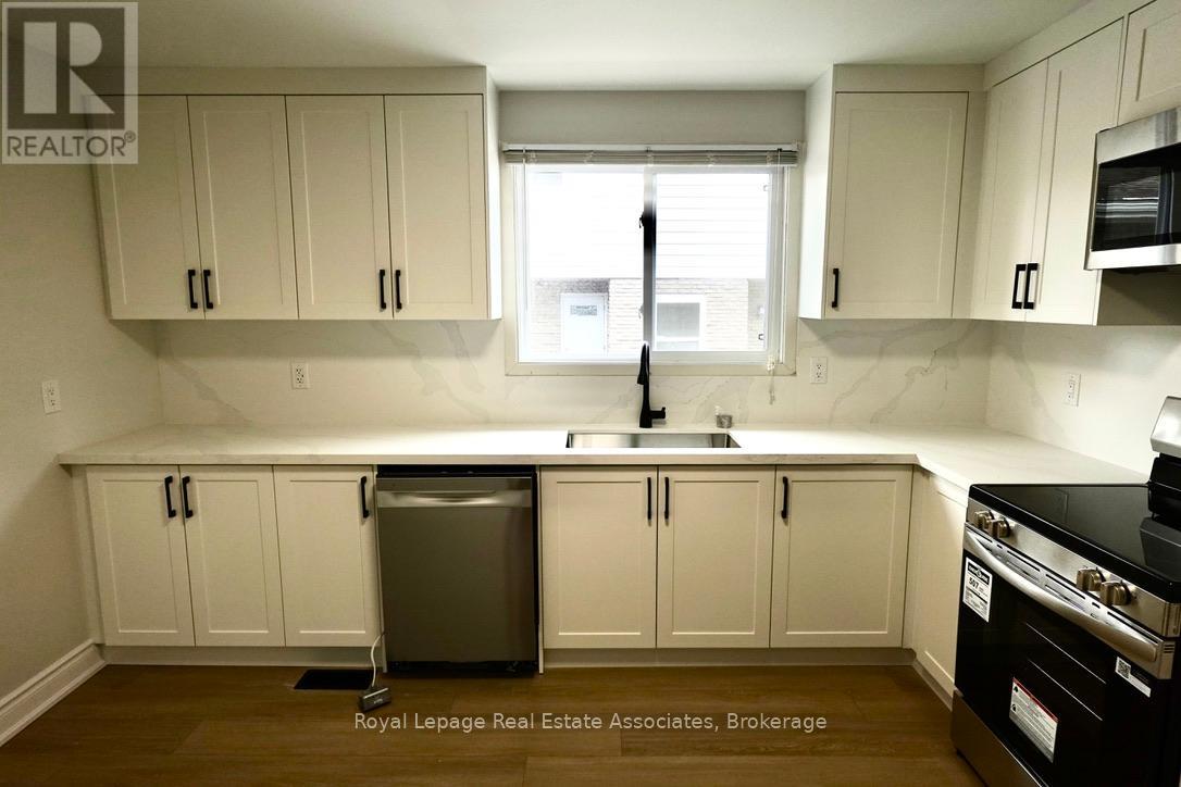 A kitchen with white cabinets and a black stove top oven.