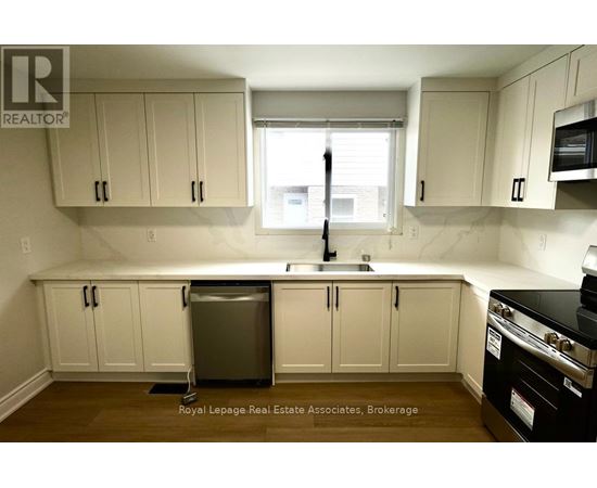 A kitchen with white cabinets and a black stove top oven.
