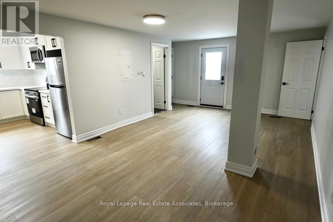 A kitchen with a refrigerator, microwave, and oven.