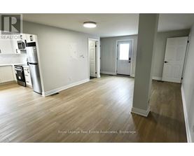 A kitchen with a refrigerator, microwave, and oven.