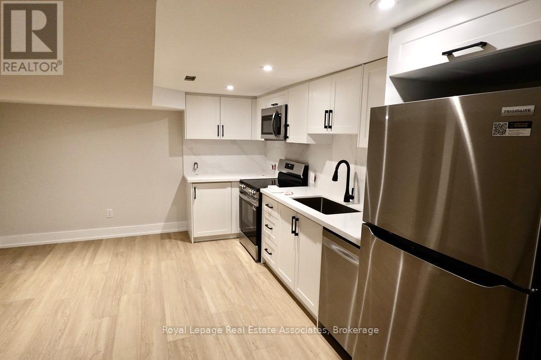 A kitchen with a refrigerator, dishwasher, and microwave.
