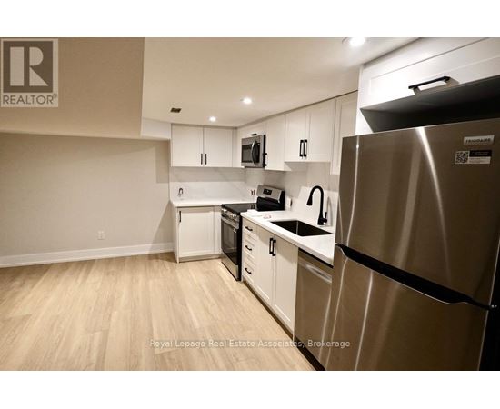 A kitchen with a refrigerator, dishwasher, and microwave.