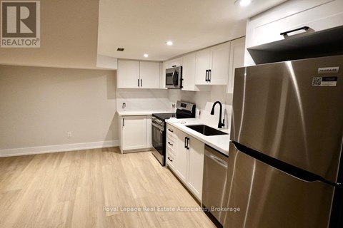 A kitchen with a refrigerator, dishwasher, and microwave.
