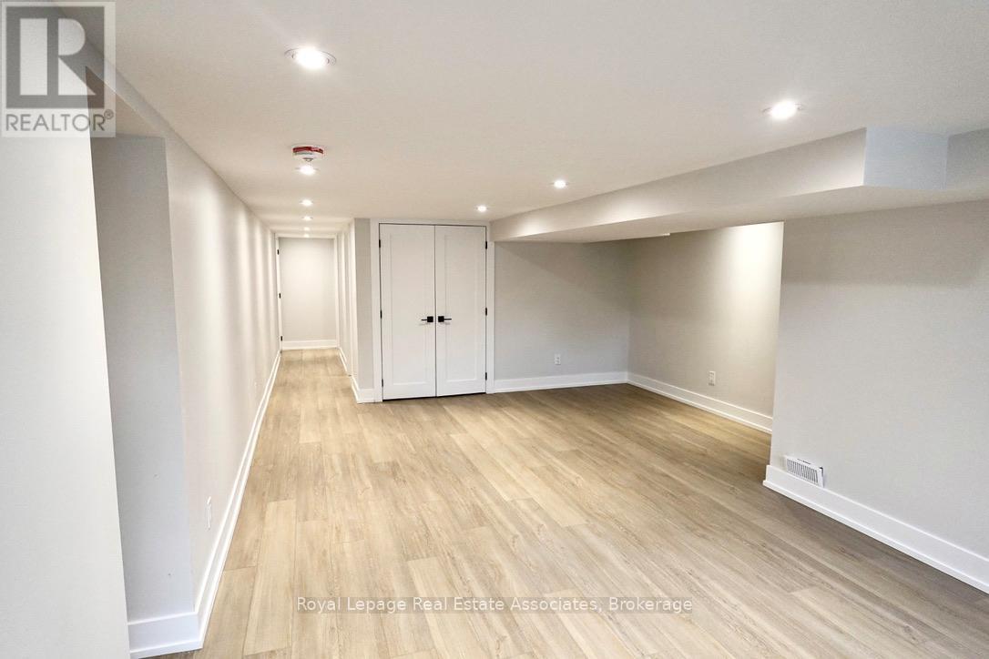 A spacious room with wooden flooring and white walls.