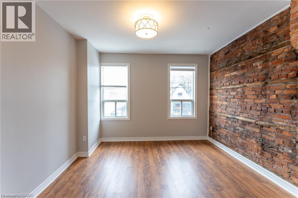 A room with a brick wall and wooden floors.