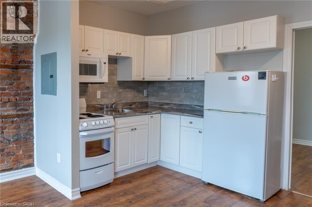 A kitchen with white appliances and cabinets.