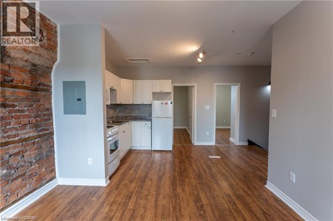 A kitchen with white cabinets and a brick wall.