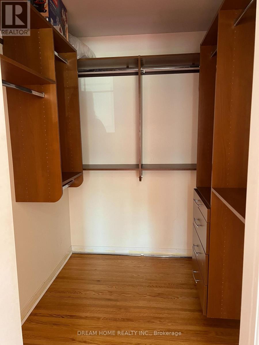 A small, empty room with wooden floors and a window with blinds.