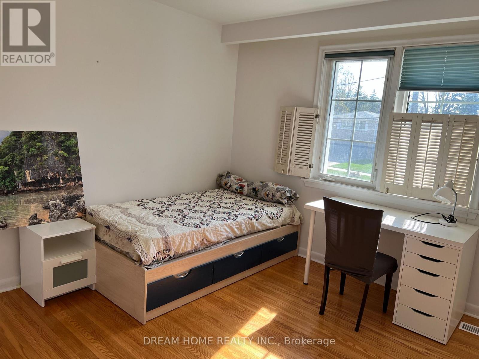 A bedroom with a bed, desk, and chair.