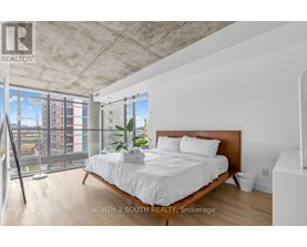 A bedroom with a large bed and a view of the city.