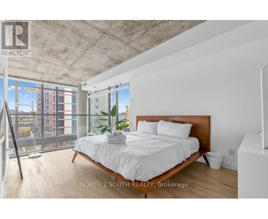 A bedroom with a large bed and a view of the city.