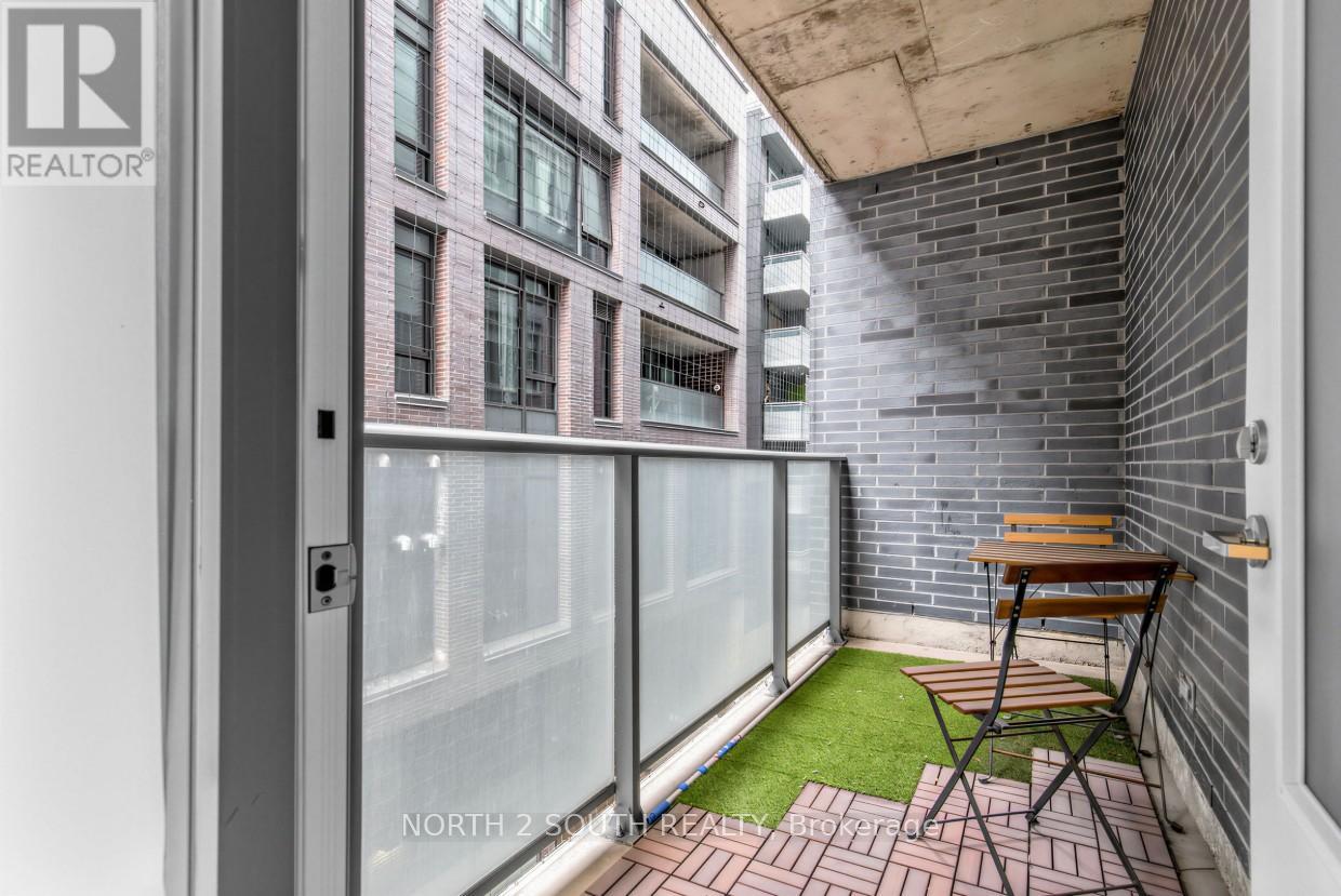 A balcony with a table and chairs overlooking a building.