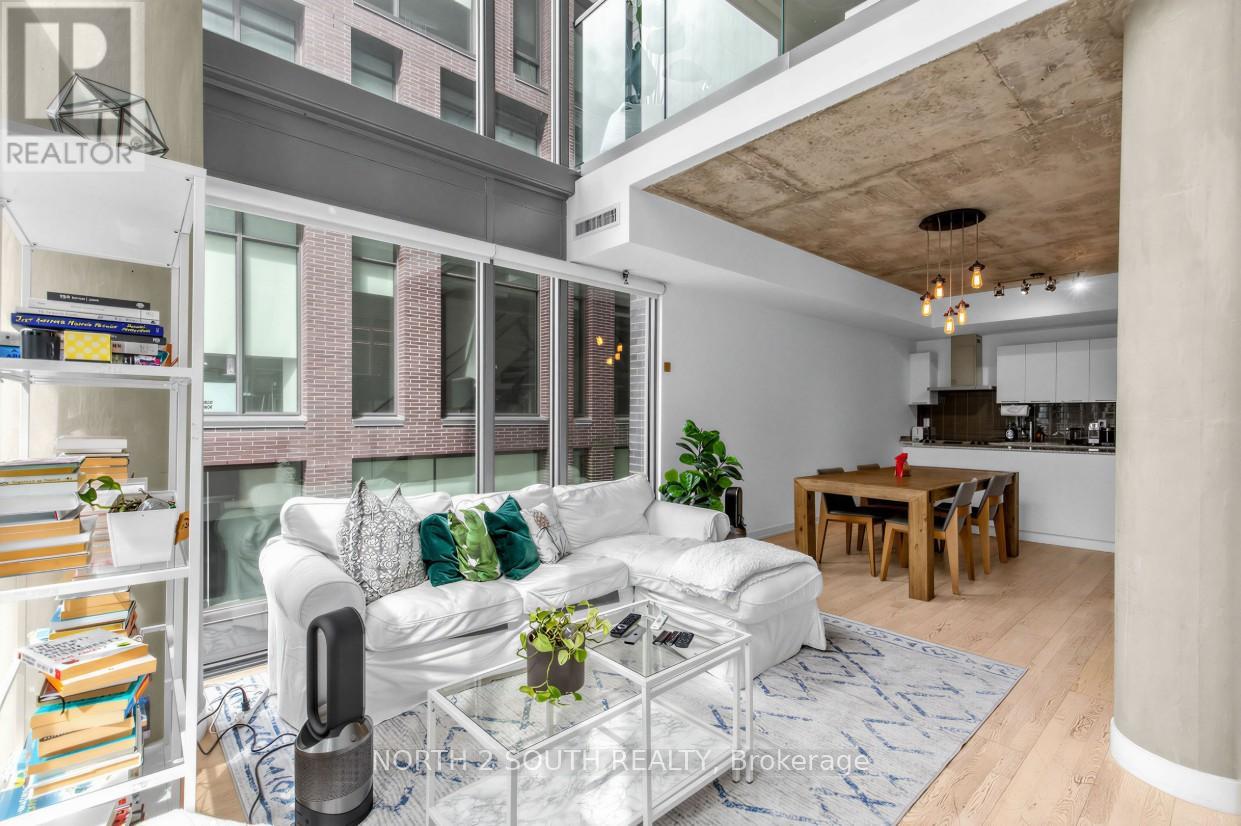 A living room with a white couch and a glass coffee table.