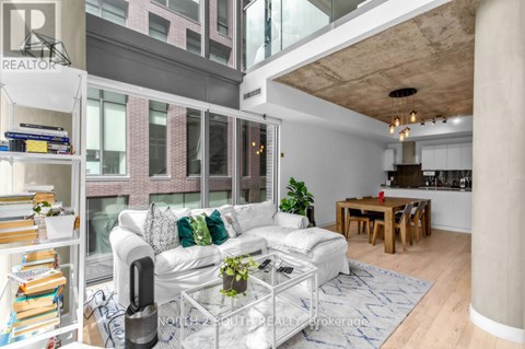 A living room with a white couch and a glass coffee table.