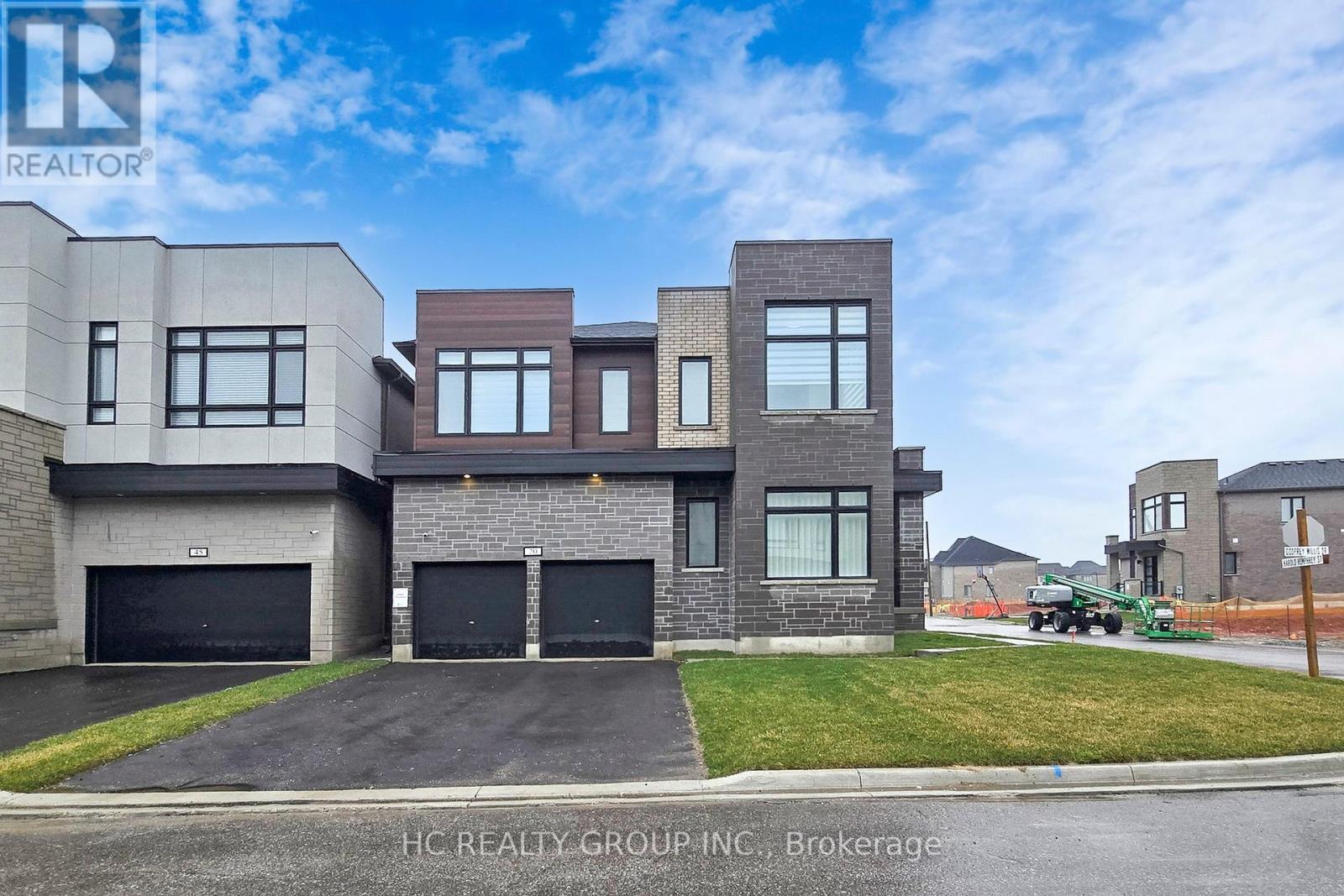 A modern house with a grey and brown exterior is for sale.