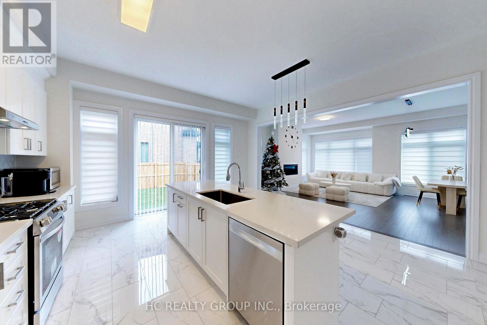 A modern kitchen with white cabinets and a marble floor.