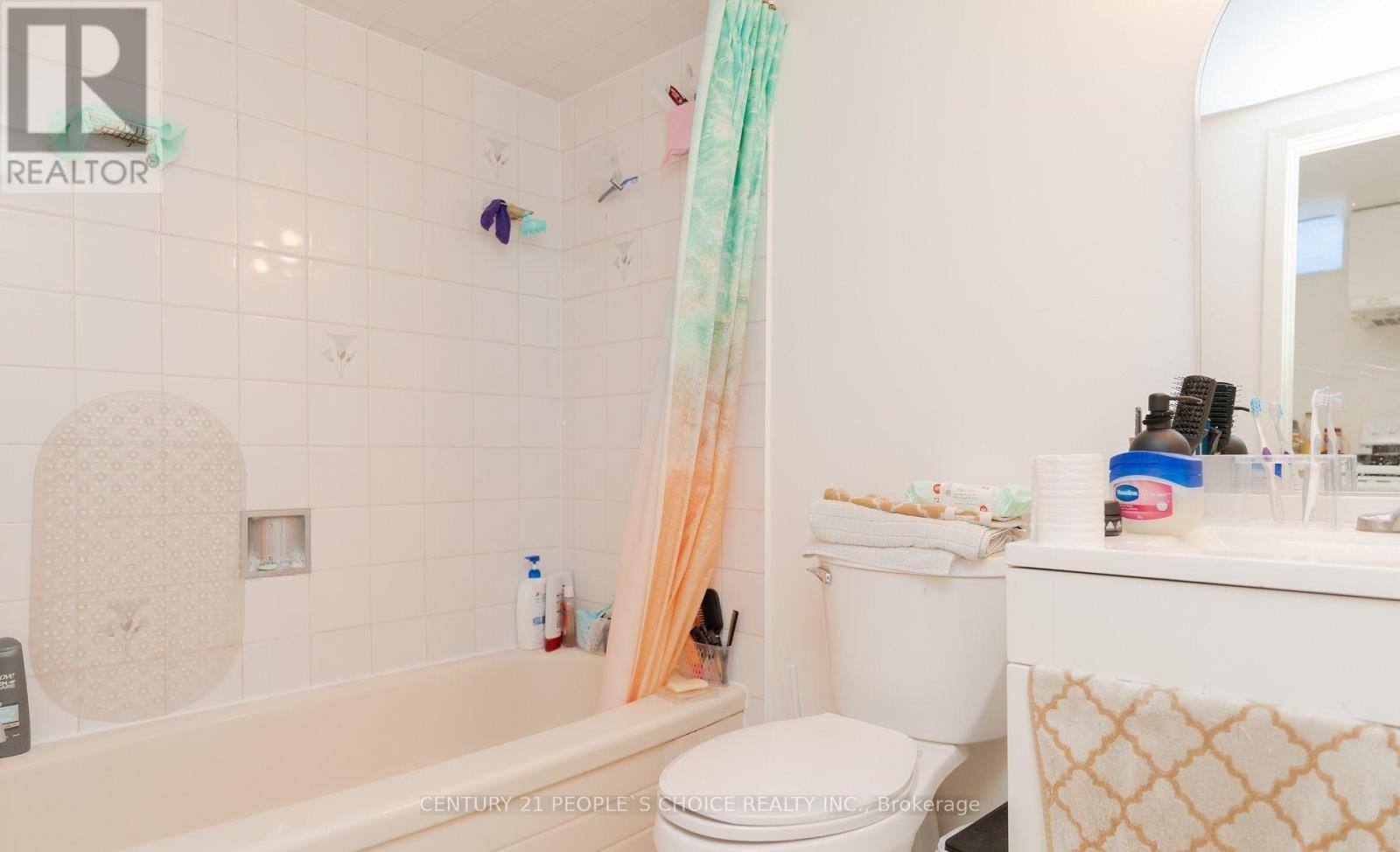 A bathroom with a white toilet, a bathtub, and a sink.